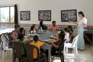Photos de groupe montrant les enfants du Centre Fiers et Forts entrain de déjeuner en compagnie de la fondatrice du centre, Madou.